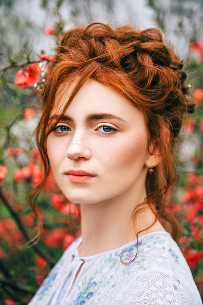 Portrait of a beautiful redhead girl in the spring garden - Фото, изображение