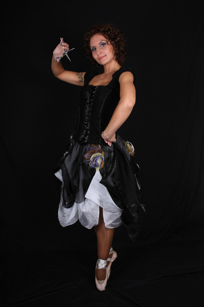 Ballerina met een schaar op zwarte achtergrond - Foto, afbeelding