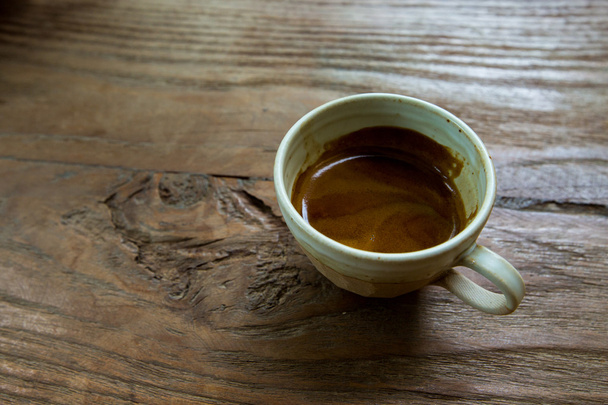 cup of espresso or hot coffee on wooden table. - 写真・画像