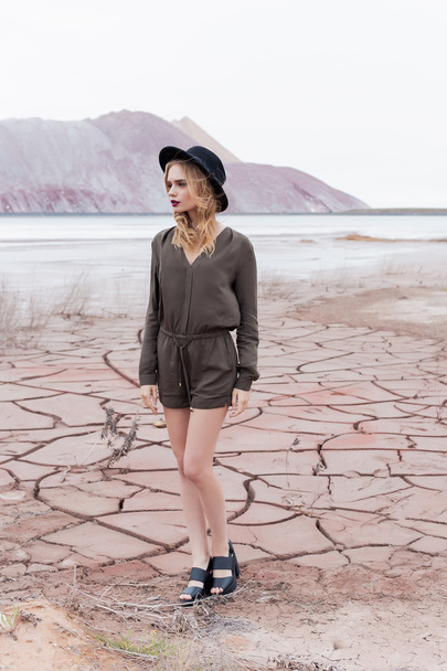 foto de moda de una hermosa chica sexy en un sombrero negro se retira en el desierto para la revista
 - Foto, Imagen