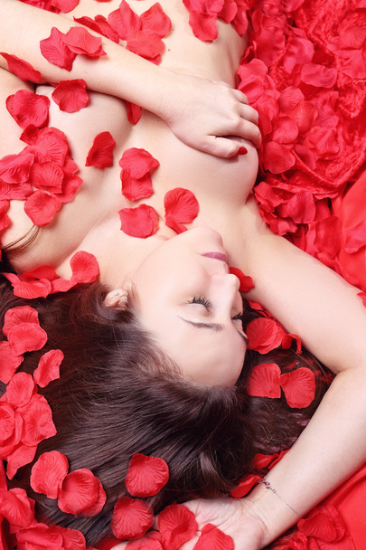 pretty woman lying in rose petals - Fotografie, Obrázek