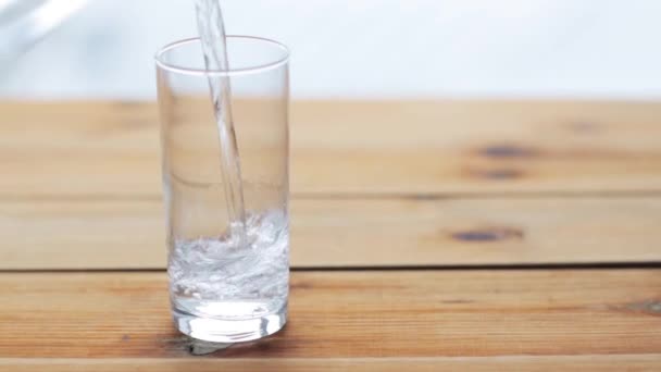 water pouring into glass on wooden table - Video