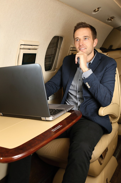Young man in the jet with open laptop - Photo, Image