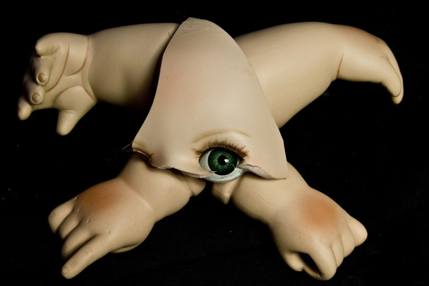 Primer plano de cabezas de muñecas rotas y piezas sobre fondo negro
 - Foto, imagen