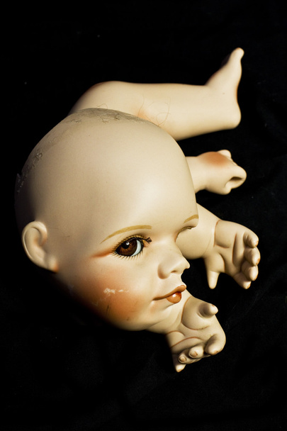 Zbliżenie na złamaną lalkę głowy i części na czarnym tle - Zdjęcie, obraz