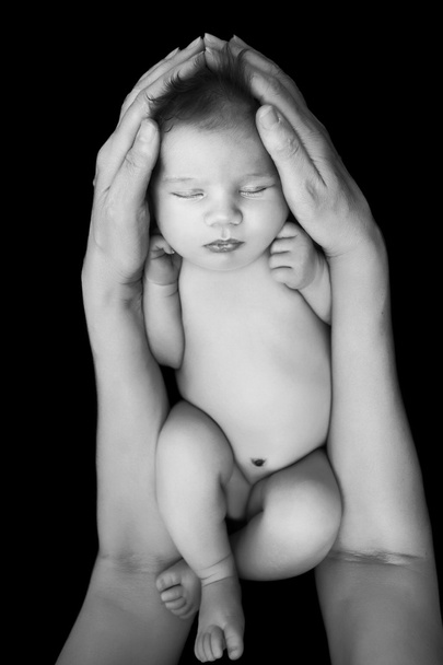 beautiful newborn baby in mother's hands. isolated on black - Photo, image