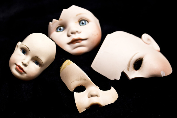 Close Up of Broken Doll Heads and Parts On Black Background - Photo, Image