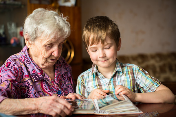 Ältere Frau mit Enkel sucht Album - Foto, Bild