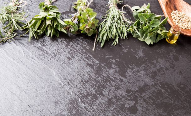 Herbs on black stone background - Valokuva, kuva