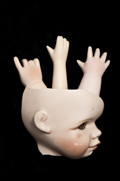 Zbliżenie na złamaną lalkę głowy i części na czarnym tle - Zdjęcie, obraz