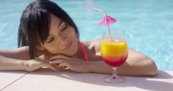 woman eyeing large tropical cocktail - Video