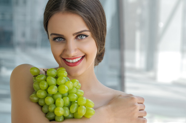 Beautiful turkish woman holding a bunch of grapes - Photo, Image