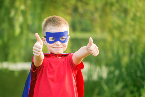  Μπράβο παιδί στο κοστούμι superhero δείχνει. T - Φωτογραφία, εικόνα