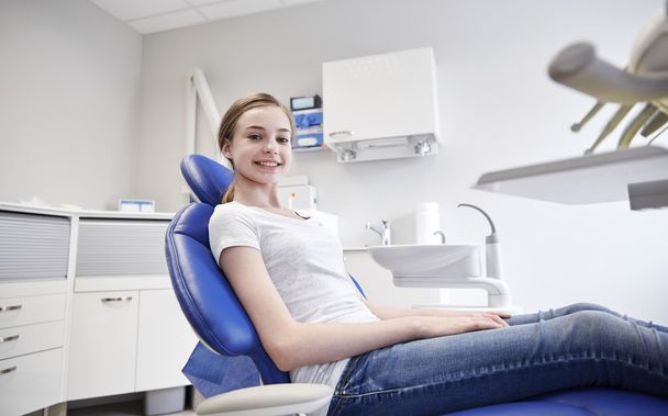 happy patient girl at dental clinic office - Foto, afbeelding