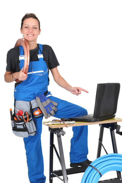Female plumber surrounded by her equipment - 写真・画像