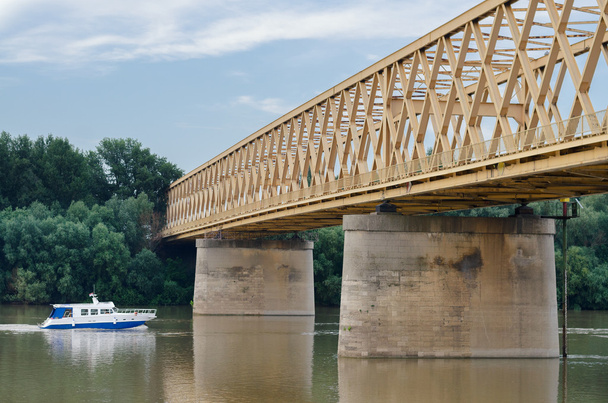 Kleine jacht reizen op de rivier en onder de brug in de zomer - Foto, afbeelding