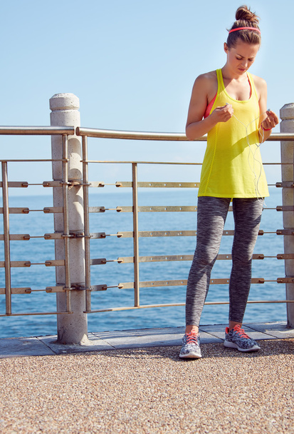 young woman in fitness outfit at embankment - Foto, Imagen