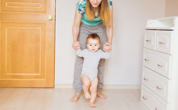 Bébé faire les premiers pas avec l'aide de la mère
 - Photo, image