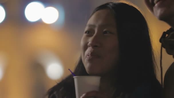 Mosolygó ázsiai lány barátja az utcán állva, és figyeli a fény show - Felvétel, videó