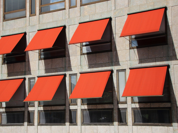 Vue en perspective sur le bâtiment moderne avec des parasols rouges
 - Photo, image