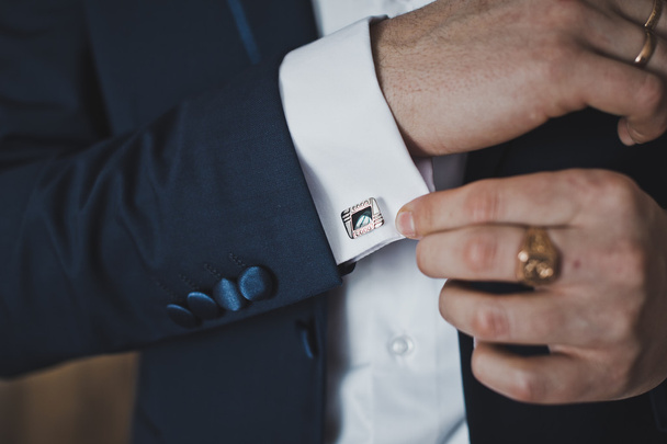 Putting on the cufflinks on the cuff of his shirt 6408. - 写真・画像