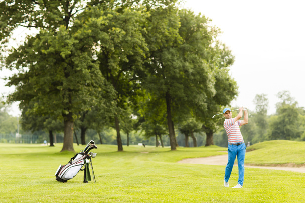 Junger Mann beim Golfspielen - Foto, Bild
