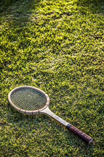 Vintage wood tennis racket on green grass garden - Photo, Image