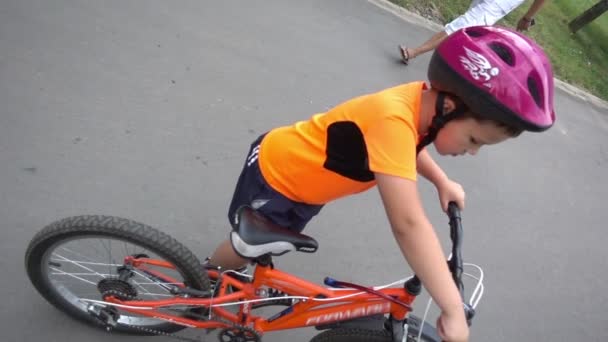 Jongen rijdt fiets in focus zoals hij camera benadert. - Video