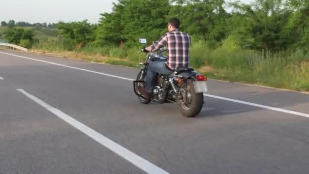 El hombre en una motocicleta pasea por la carretera. Disparo aéreo
 - Metraje, vídeo