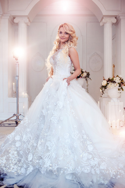 Beautiful girl bride in a magnificent dress. Luxurious light interior - Foto, imagen