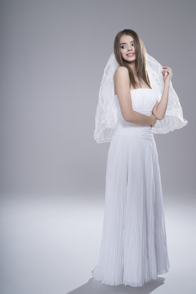 Joyeux sexy belle mariée fille brune en robe de mariée blanche sur fond blanc
 - Photo, image