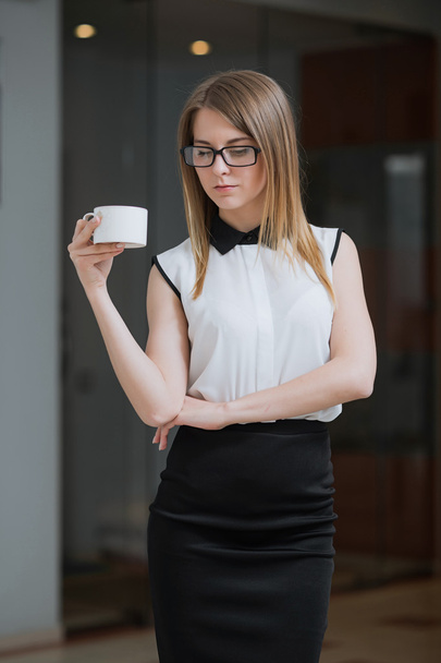 Businesswoman is in her office with a Cup of hot coffee - Fotoğraf, Görsel