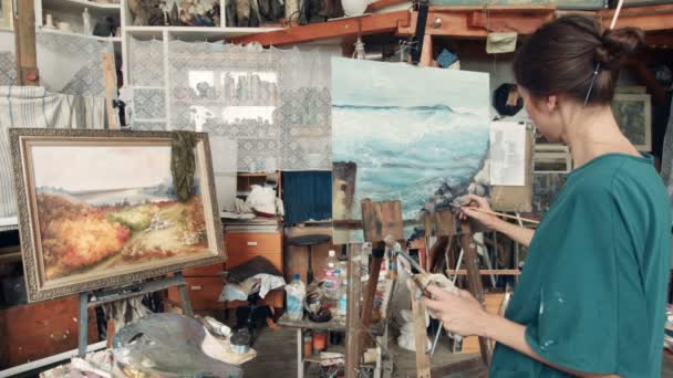 Vonzó nő művész dolgozik egy vászon - Felvétel, videó