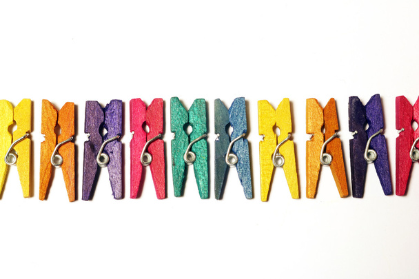 Miniature Clothes Pegs on White Background - Foto, afbeelding