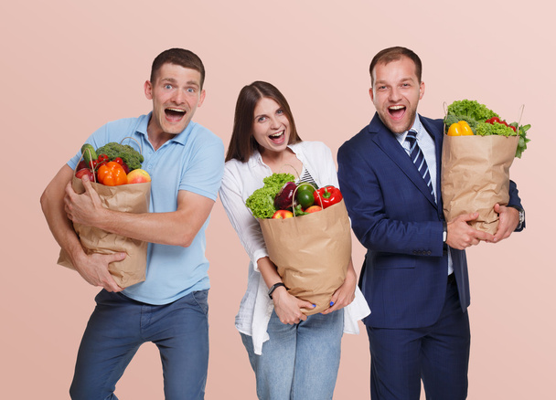 Happy people hold bags with healthy food, grocery buyers isolated - Foto, Imagen