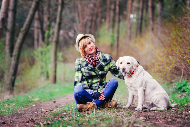 Young girl with a dog in the wood - Foto, imagen