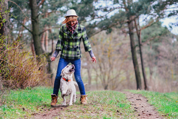 Chica joven con un perro en el bosque
 - Foto, imagen