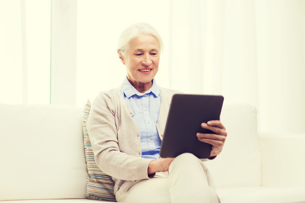 happy senior woman with tablet pc at home - Fotó, kép