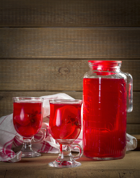 Jug and glasses with strawberry juice on vintage background - Foto, afbeelding