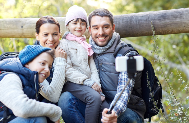 happy family with smartphone selfie stick in woods - Zdjęcie, obraz