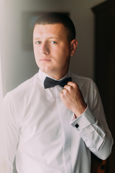 Portrait of elegant handsome young fashion man in white shirt and bow-tie - Foto, afbeelding