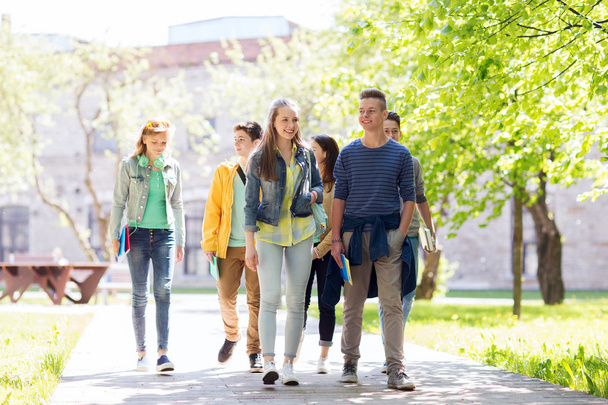 group of happy teenage students walking outdoors - Фото, изображение