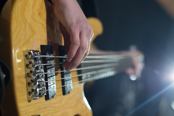 гітарні руки грають на гітарі над чорним
 - Фото, зображення