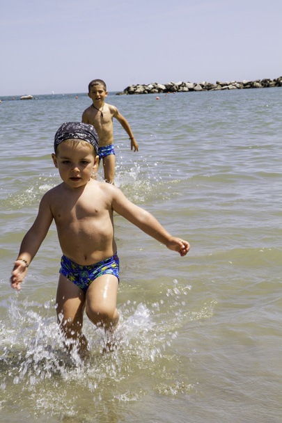 glückliches Kind rennt zum Schwimmen ins Meer, Urlaub in Italien - Foto, Bild