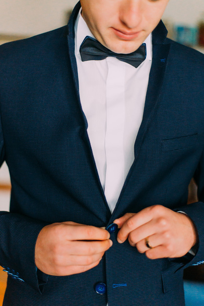 Close-up shot of young caucasian man wearing stylish elegant suit with bow tie - Foto, Imagen