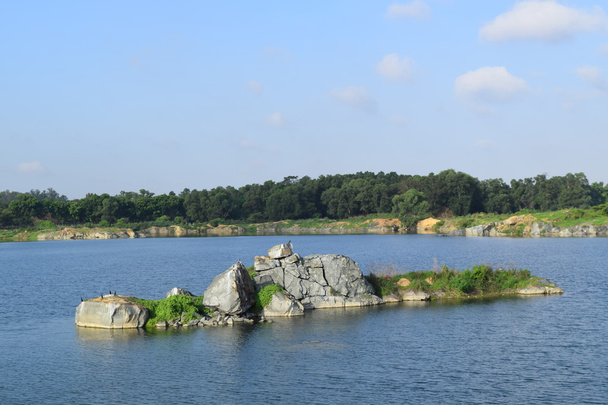 kivinen järvi, jossa pieni jokisaari
  - Valokuva, kuva