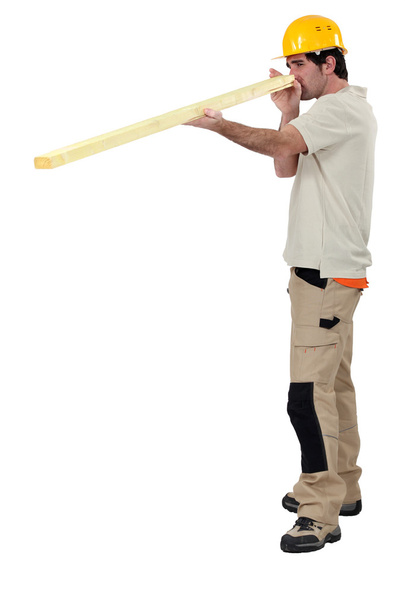 Craftsman measuring a wooden board - Foto, imagen