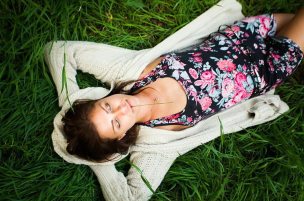 Model laying at green grass at summer time - Fotoğraf, Görsel