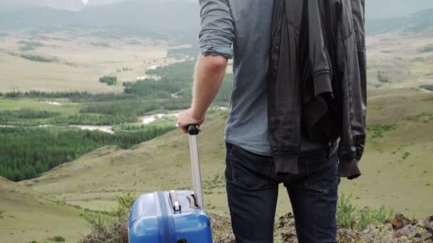 Business man with suitcase on the top of the mountain in sunset - Filmagem, Vídeo