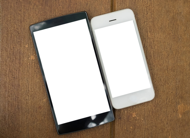 два порожніх мобільних на дерев'яному столі. Розумний телефон з порожнім екраном і можуть бути додані ваші тексти або інші на смартфоні. вид зверху
 - Фото, зображення